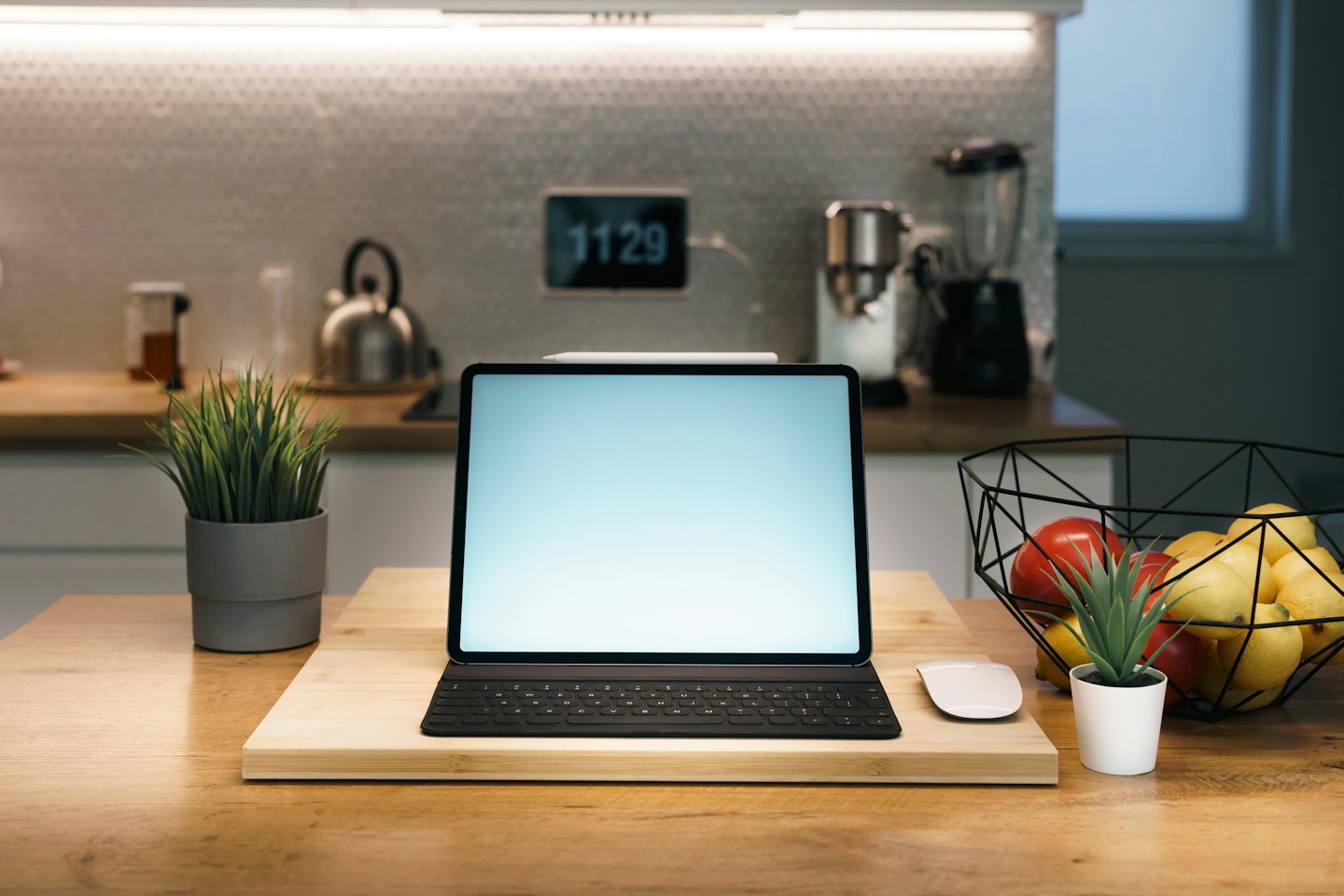 Tablet and keyboard workspace on a modern kitchen counter.