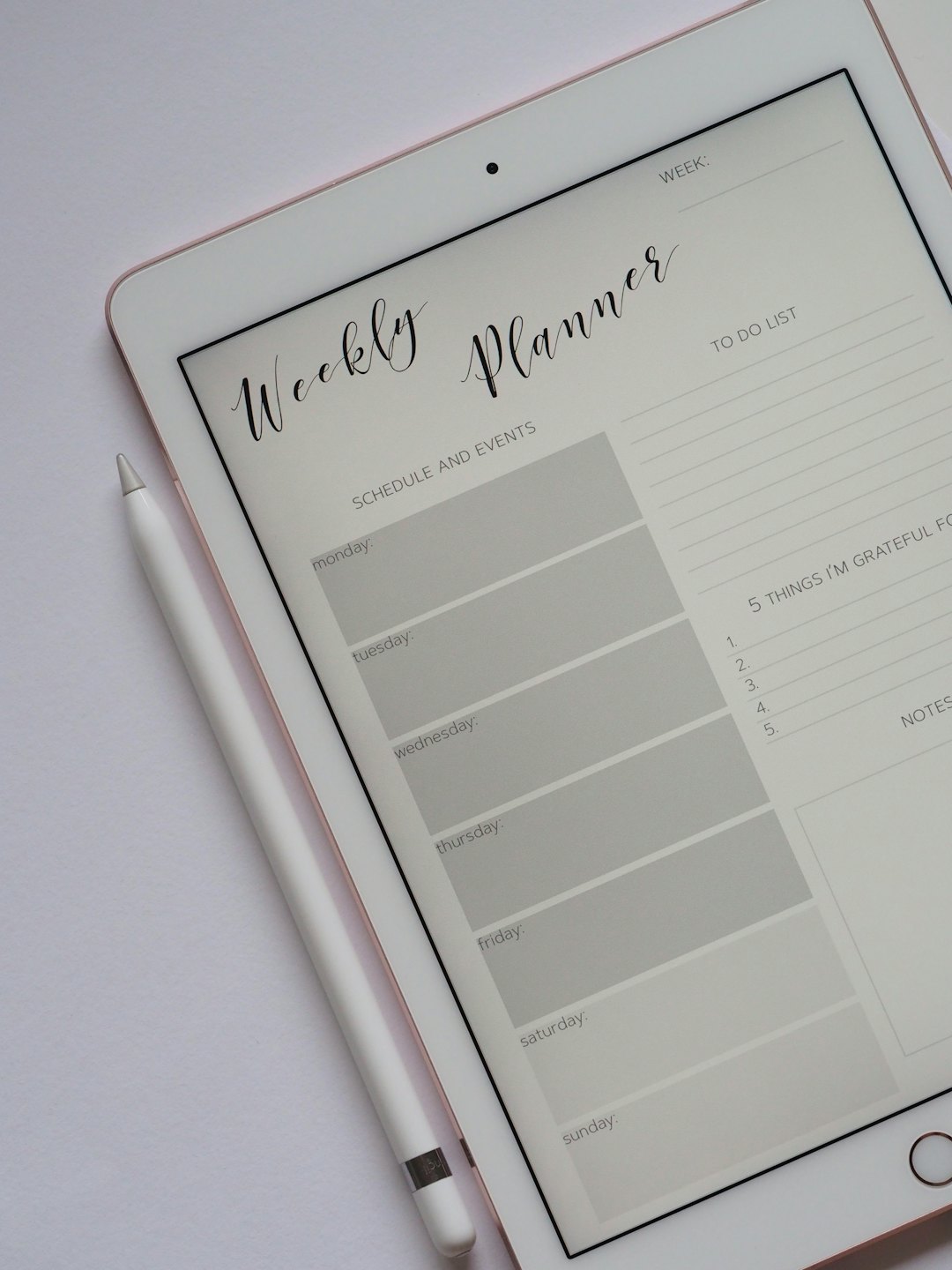 Digital weekly planner on a rose gold tablet with Apple Pencil.